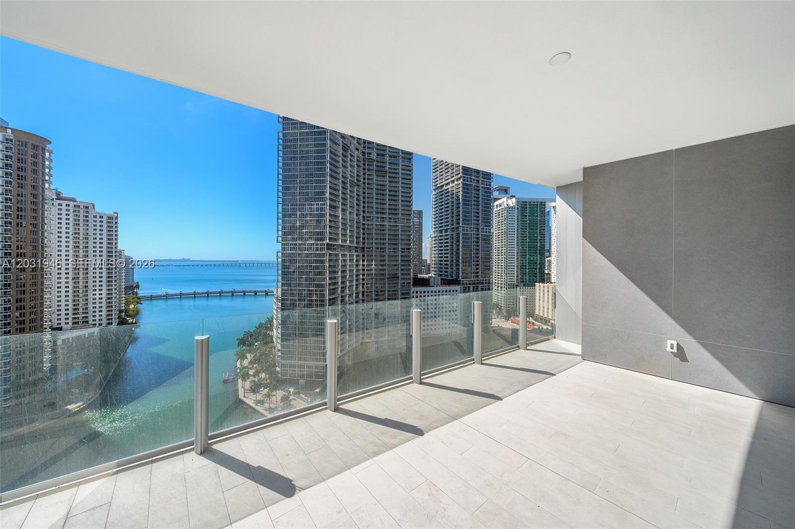 A modern balcony with glass railings overlooks a bay and city skyline — 300 Biscayne Blvd Way # 1904C, Miami FL 33131, MIAMI, FL