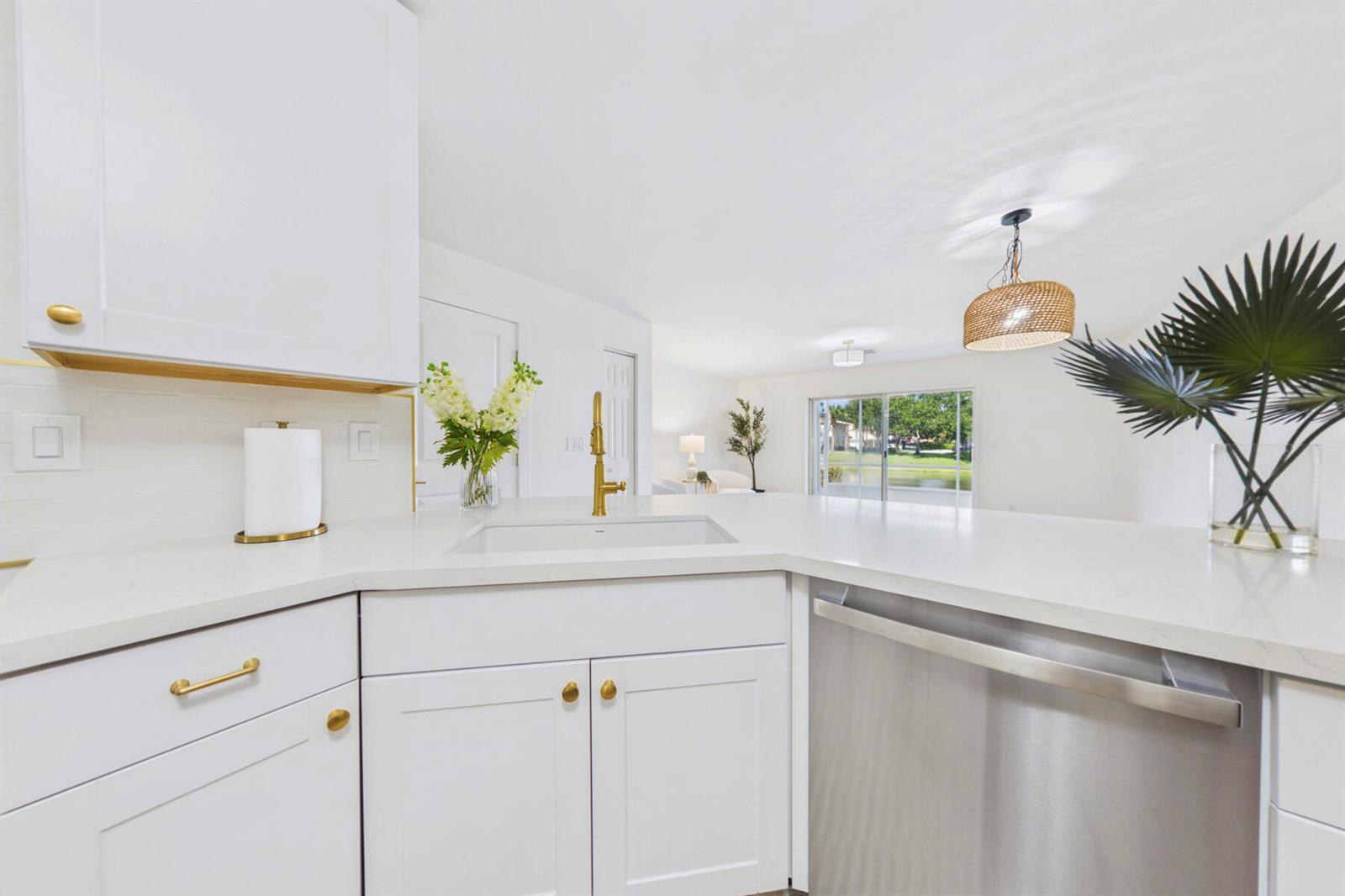 A white kitchen with gold hardware, a stainless steel dishwasher, and a view of water — 262 Timberwalk Trail, Jupiter FL 33458, JUPITER, FL