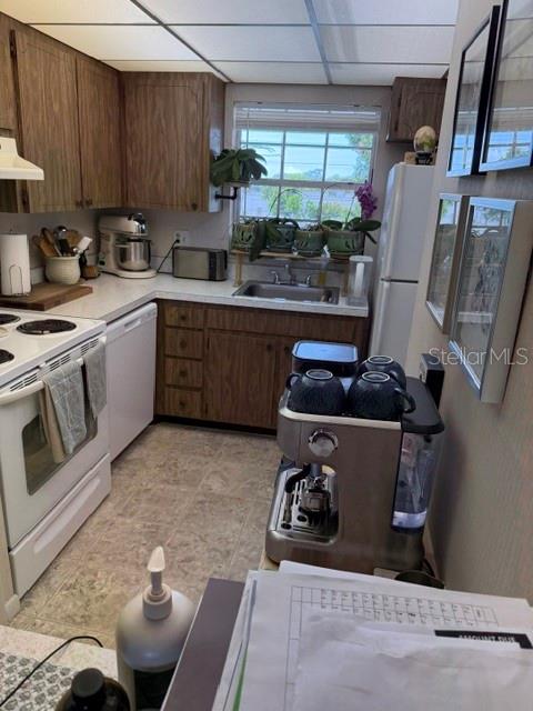 A kitchen features wood cabinets, a stainless steel espresso machine, and a window above the sink — 10530 77TH TERRACE UNIT 323, SEMINOLE, FL