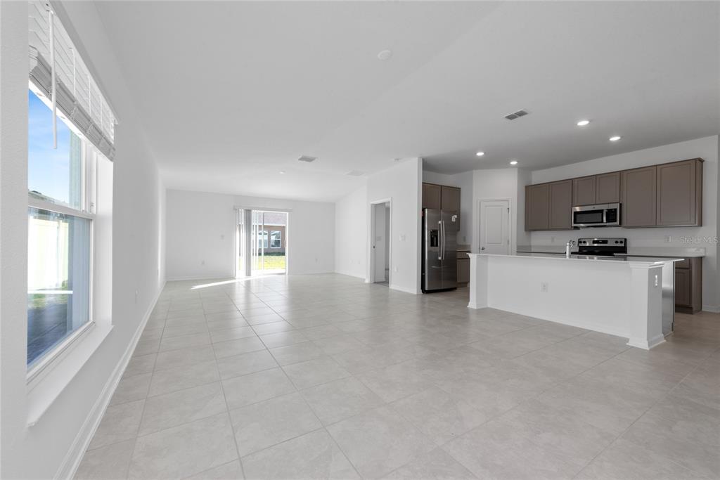 A modern kitchen features a white island, stainless steel appliances, and gray cabinetry — 346 RUSTIC RAIL DRIVE, LAKE WALES, FL