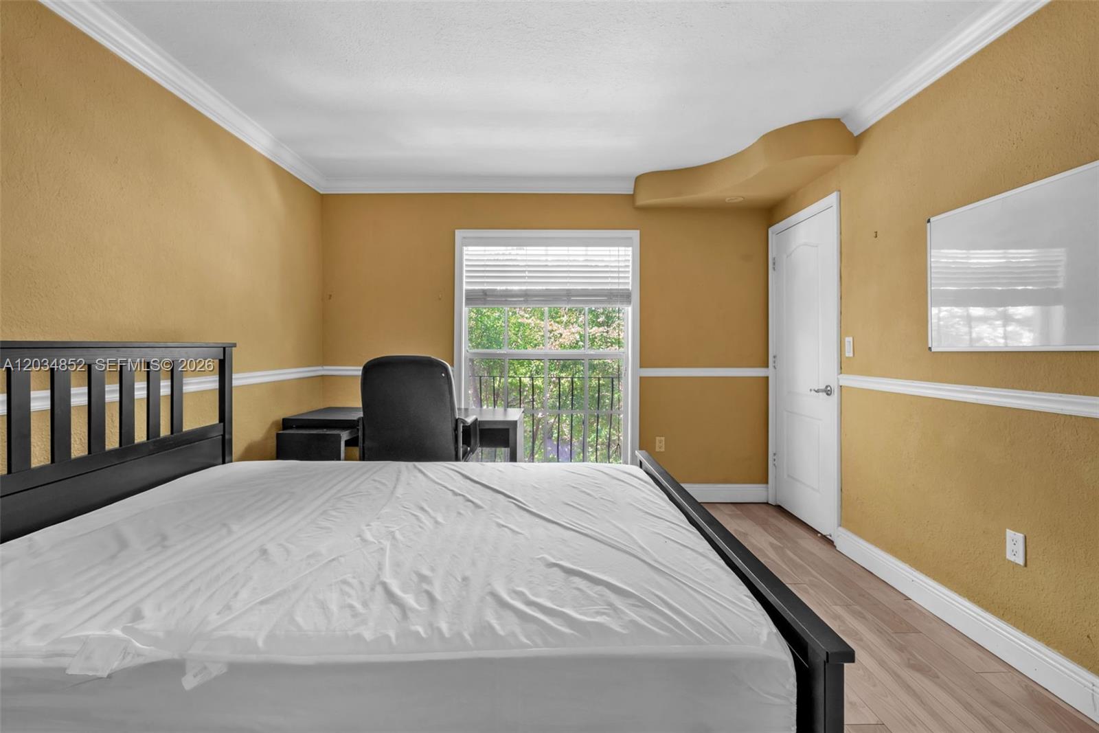 A bedroom features mustard-yellow walls, a black bed frame, a desk, and a window — 3245 Virginia St # 65, Miami FL 33133, MIAMI, FL