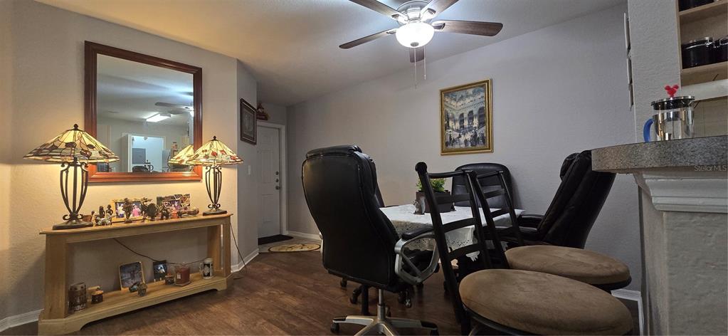 A dining area features a wooden console table, a table with chairs, and a ceiling fan — 7606 PISSARRO DRIVE UNIT 14106, ORLANDO, FL