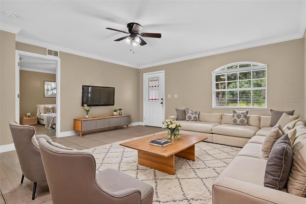 A living room features a large sectional sofa, a coffee table, and a ceiling fan — 2820 LIVINGSTON ROAD, AVON PARK, FL