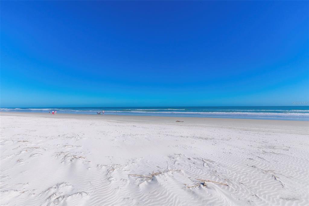 A wide, sandy beach meets the ocean under a clear blue sky — 4863 S ATLANTIC AVENUE, PONCE INLET, FL