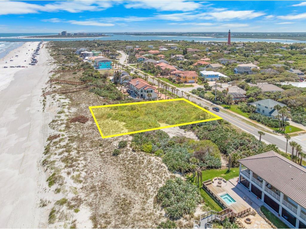 An aerial view shows a vacant, rectangular oceanfront lot outlined in yellow next to a beach — 4863 S ATLANTIC AVENUE, PONCE INLET, FL