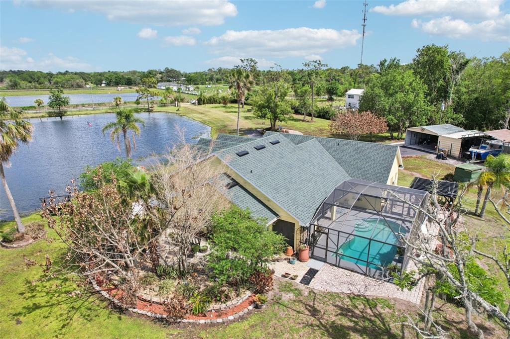 An aerial view of a house with a screened pool, patio, and a nearby pond — 3954 MCCLELLAND ROAD, ST CLOUD, FL