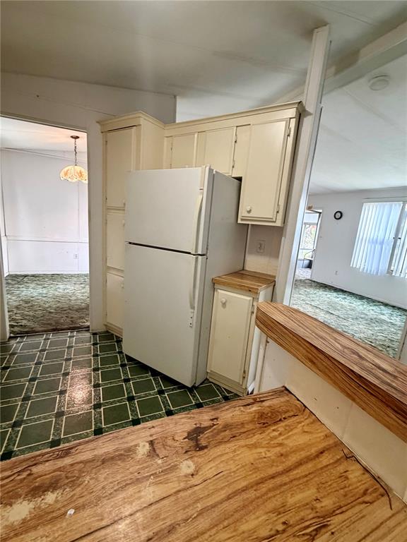 A kitchen features a white refrigerator, light-colored cabinets, and a wood-topped counter — 820 WATER OAKS DRIVE, WINTER HAVEN, FL