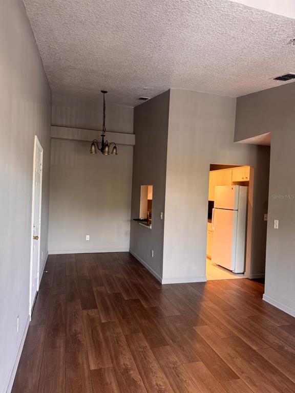 An interior view shows a dining area with wood-look flooring and a hanging light fixture — 1132 S PINE RIDGE CIRCLE UNIT 32, SANFORD, FL