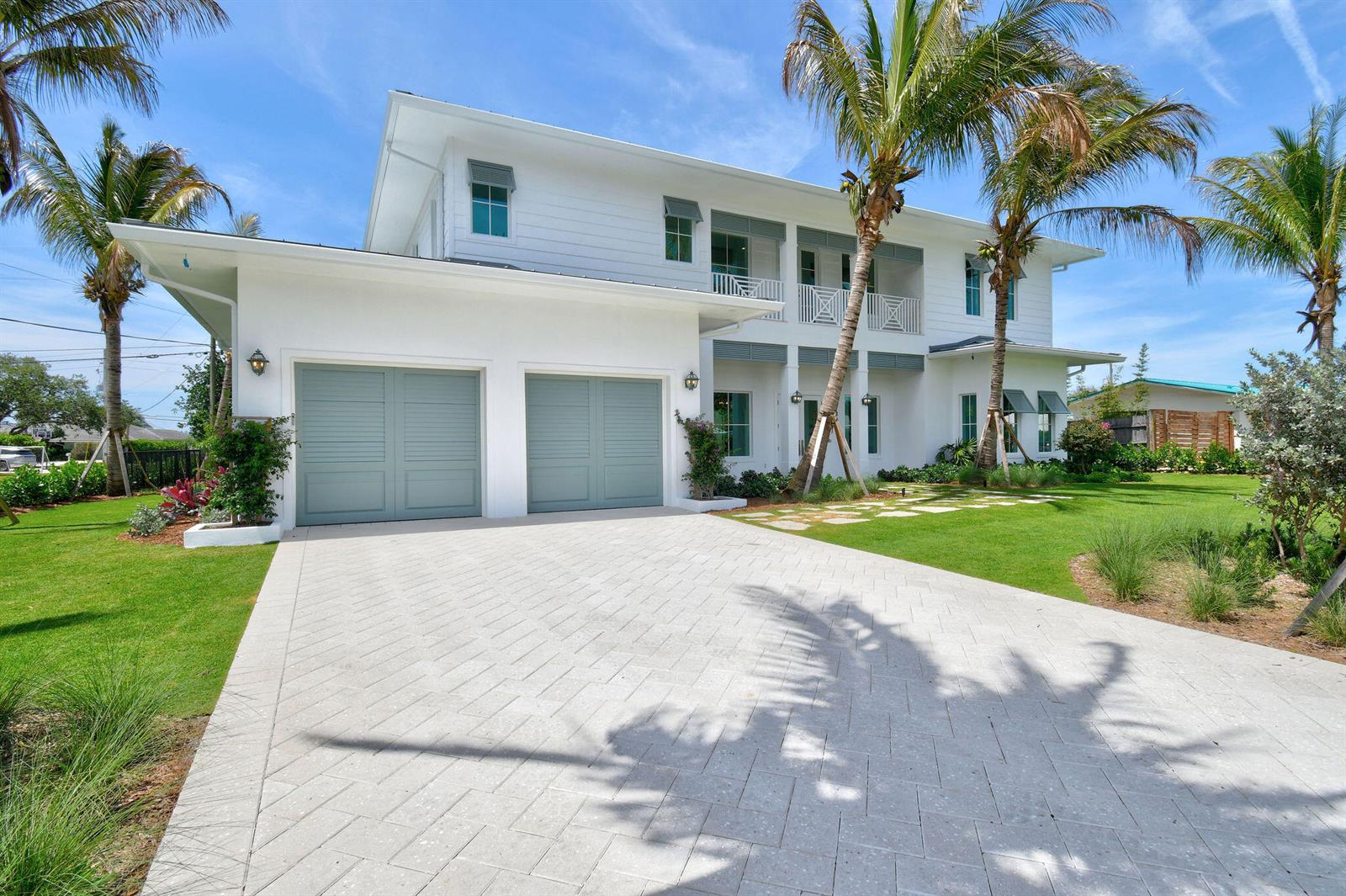 A two-story white house with a paved driveway, two-car garage, and palm trees — 91 Golfview Drive, Tequesta FL 33469, TEQUESTA, FL