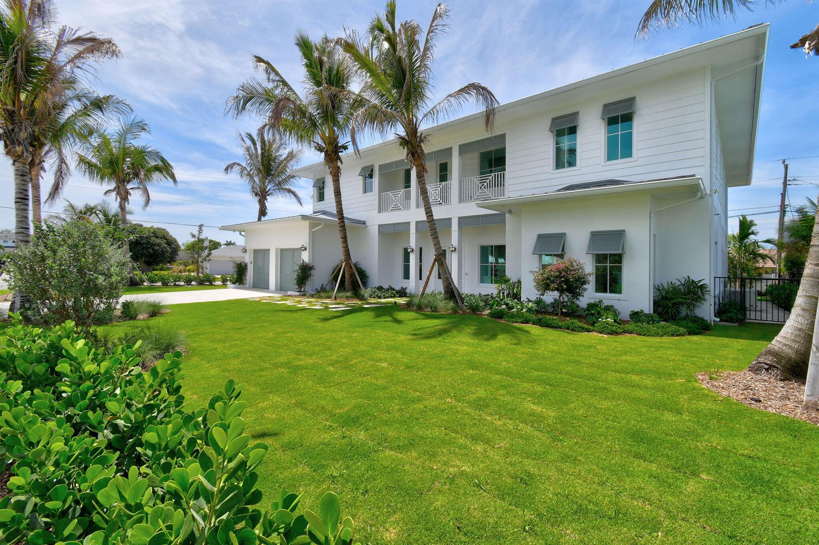 A two-story white house with a green lawn, palm trees, and a paved driveway — 91 Golfview Drive, Tequesta FL 33469, TEQUESTA, FL