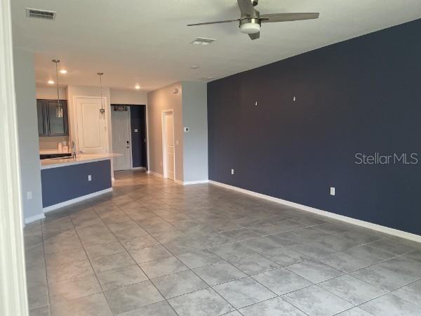 An open-concept living area features a kitchen with a breakfast bar and dark blue walls — 1125 SAGUARO STREET, HAINES CITY, FL