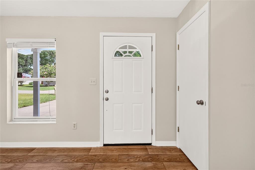 An interior view showing a white front door, a window, and a closet door — 3174 SE 6TH PLACE, OCALA, FL