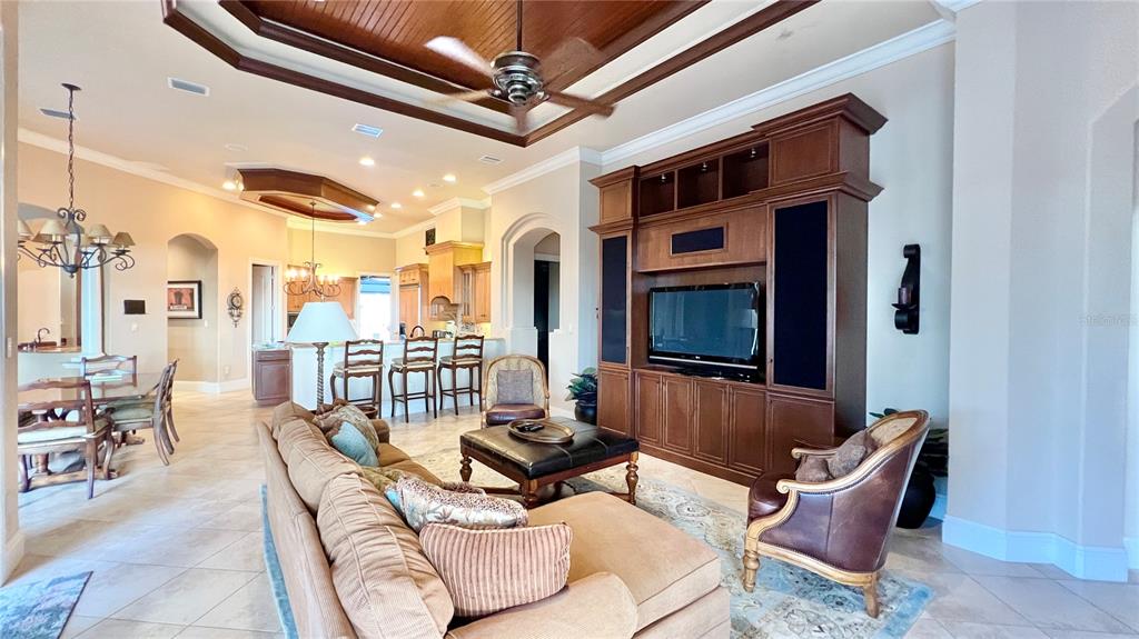 A living room features a coffered ceiling, large entertainment center, and an open kitchen area — 17784 SW 61ST LANE ROAD, DUNNELLON, FL