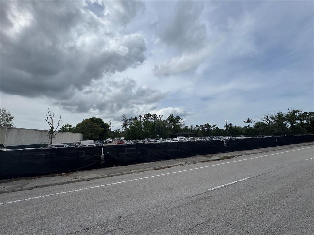 A large, fenced-in parking lot filled with many vehicles sits beside a paved road — 5515/5517 SHAD ROAD, JACKSONVILLE, FL