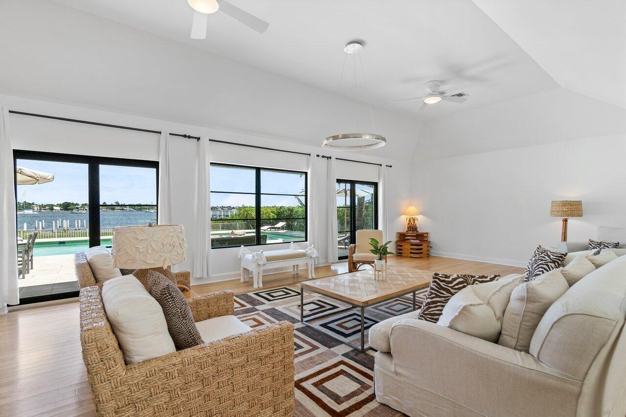 A bright living room features a vaulted ceiling, large windows, and a view of a pool — 210 S Lake Drive, Lantana FL 33462, LANTANA, FL