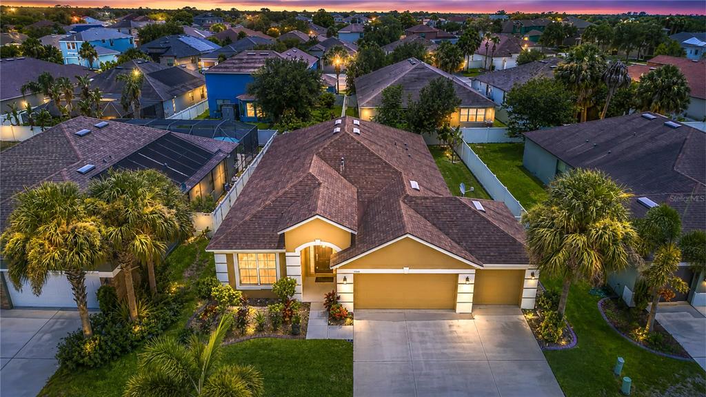 A grassy backyard features a large tree, a white vinyl fence, and a tan house — 8443 WHITE POPLAR DRIVE, RIVERVIEW, FL