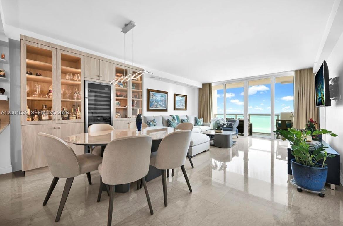 A bright dining and living area features light wood cabinetry, tile floors, and ocean views — 5601 Collins Ave # 903, Miami Beach FL 33140, MIAMI BEACH, FL