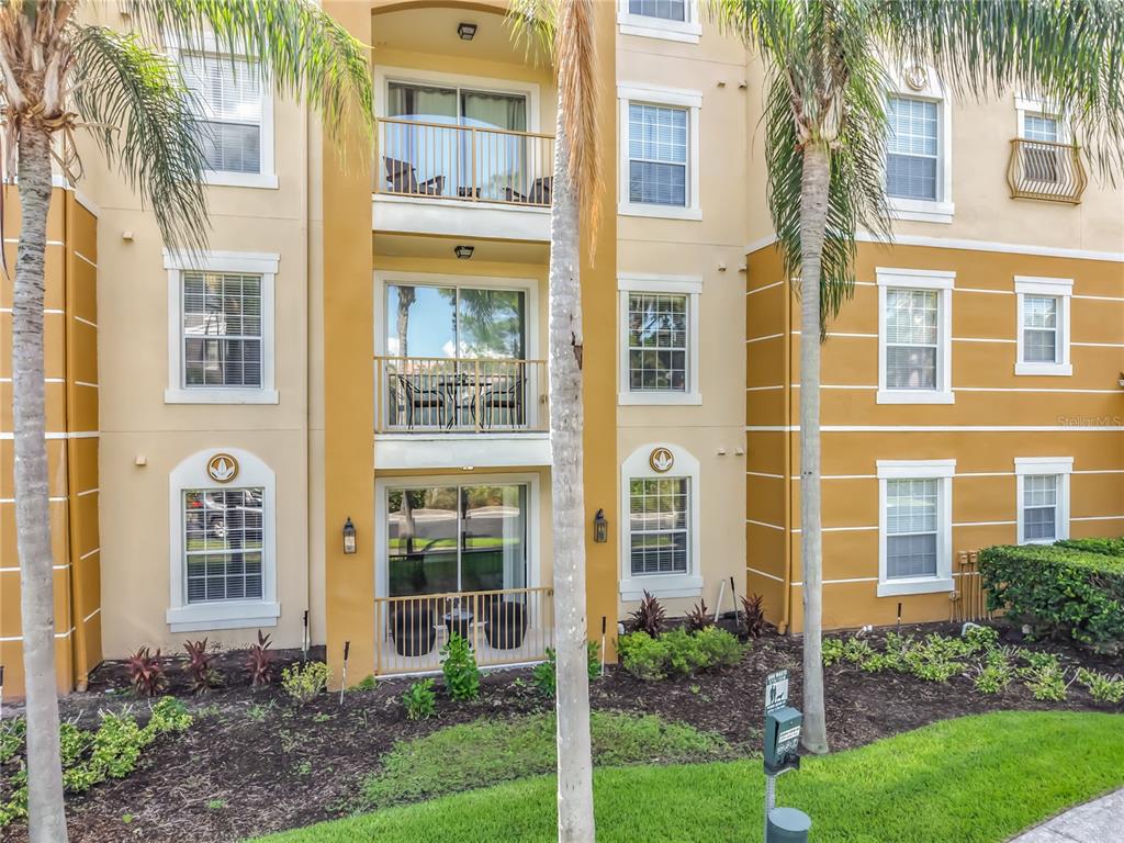 Exterior view of a multi-story apartment building with balconies and palm trees — 4814 CAYVIEW AVENUE UNIT 10213, ORLANDO, FL