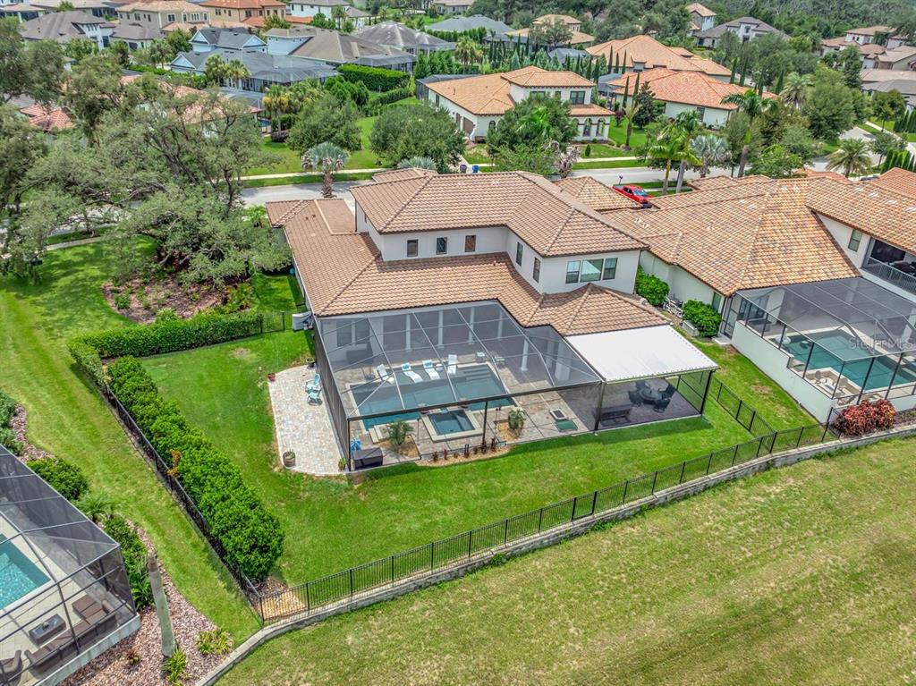 An aerial view of a two-story house with a screened-in pool and backyard patio — 14922 FISHHAWK PRESERVE DRIVE, LITHIA, FL