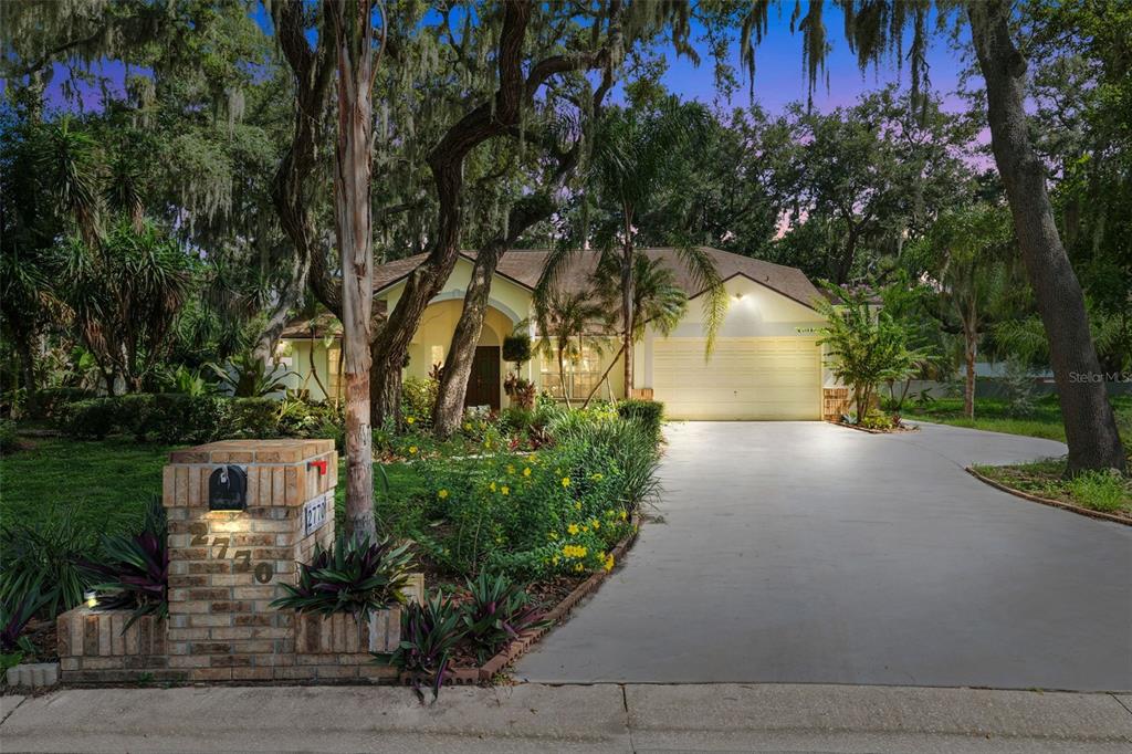 A single-story house with a brick mailbox, concrete driveway, and mature trees in the yard — 2770 BUCKHORN OAKS DRIVE, VALRICO, FL