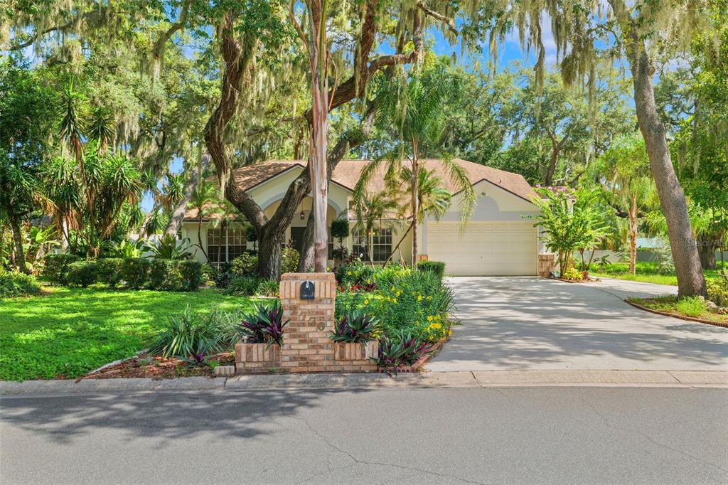 A single-story house with a two-car garage, brick mailbox, and mature trees in the yard — 2770 BUCKHORN OAKS DRIVE, VALRICO, FL