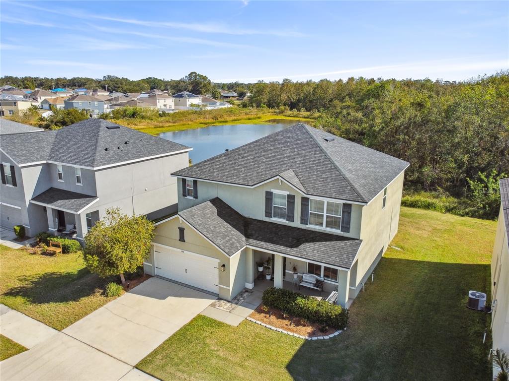 An aerial view shows a two-story suburban house with a garage and a backyard pond — 3416 SAN MOISE PLACE, PLANT CITY, FL