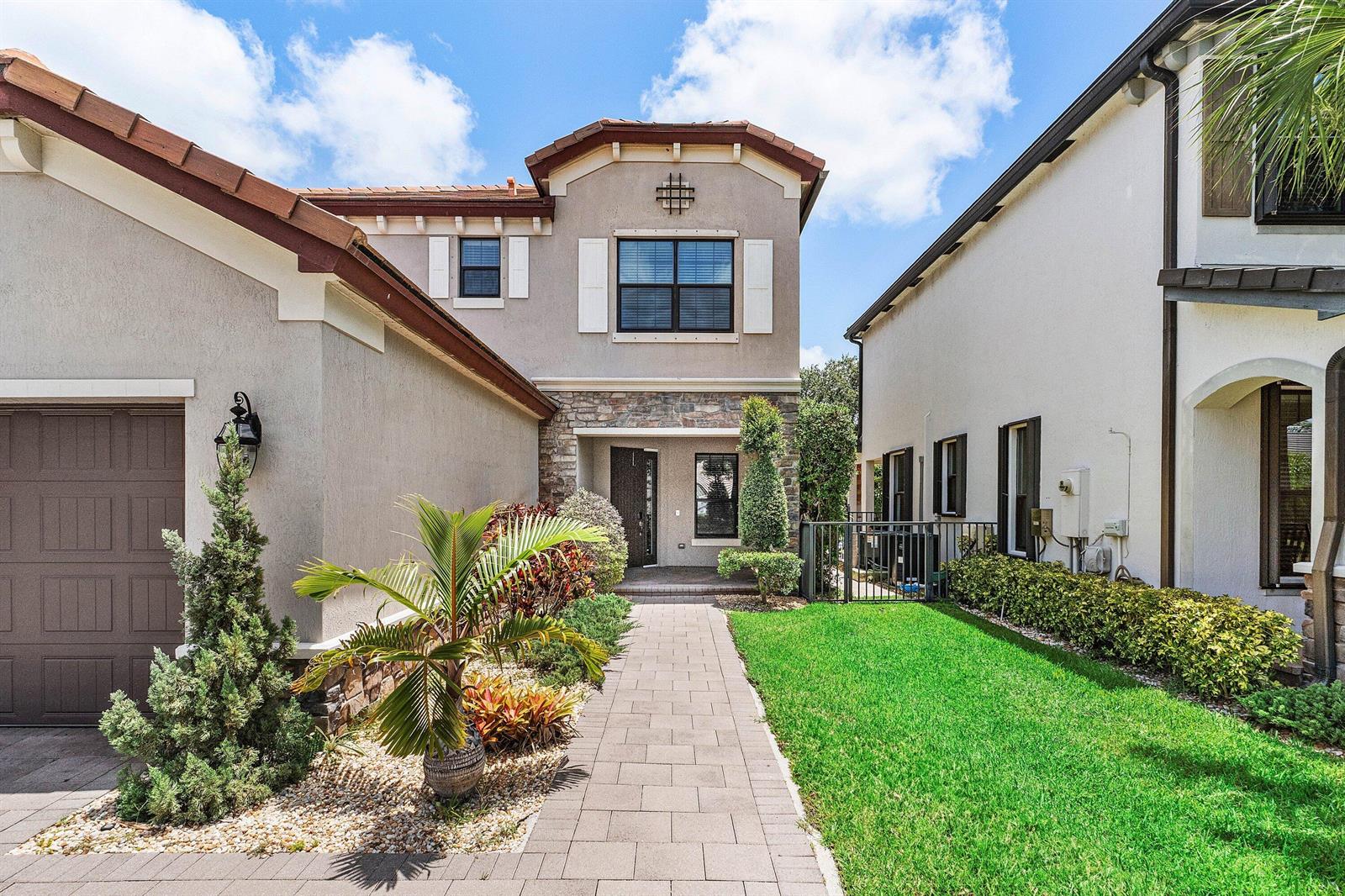 A paved walkway leads to the front entrance of a two-story house with stucco siding — 5428 Sandbirch Way, Lake Worth FL 33463, LAKE WORTH, FL