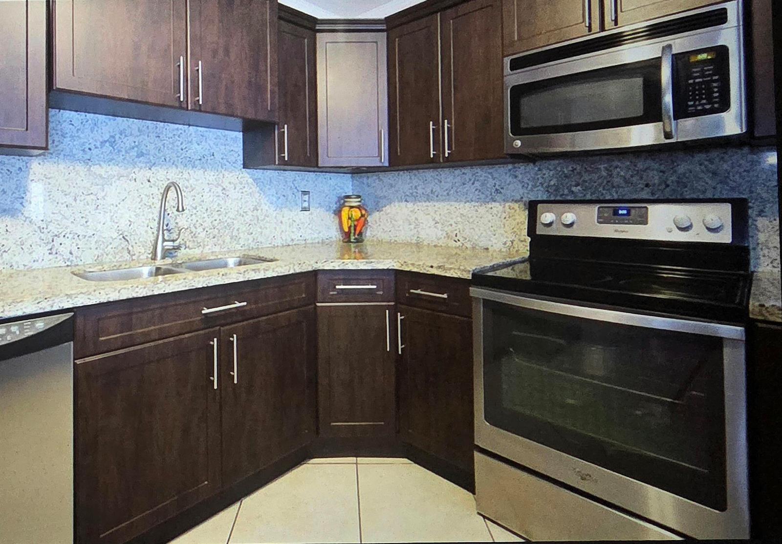 A kitchen features dark wood cabinets, stainless steel appliances, and speckled granite countertops — 2441 PINE TREE Drive, Miramar FL 33023, MIRAMAR, FL
