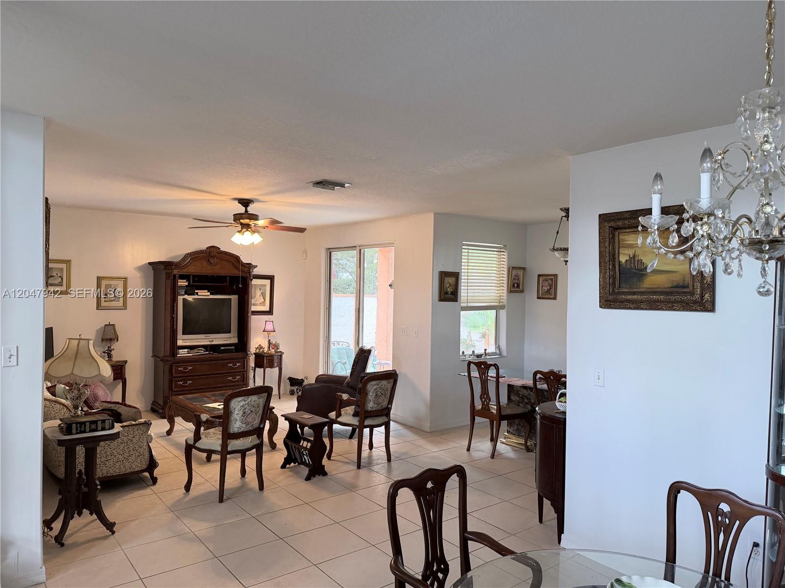 A living and dining area features tile floors, a ceiling fan, and traditional wooden furniture — 10824 NW 51st Ln, Doral FL 33178, DORAL, FL