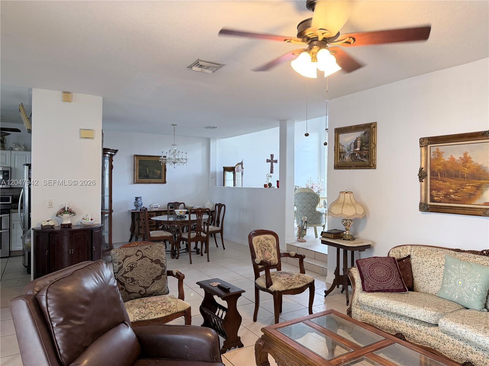 A living room and dining area feature tile floors, traditional furniture, and a ceiling fan — 10824 NW 51st Ln, Doral FL 33178, DORAL, FL