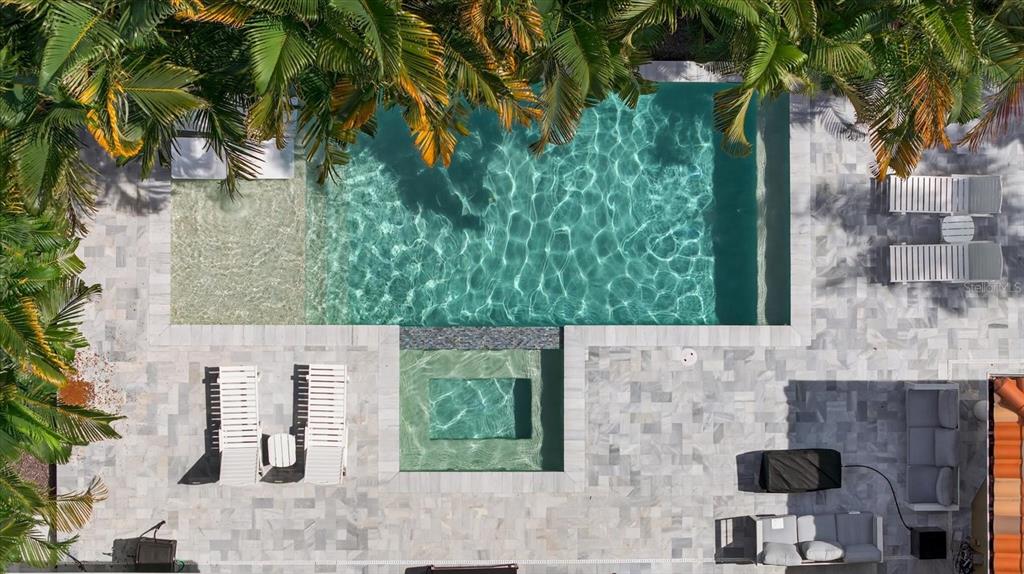 An aerial view of a swimming pool and spa surrounded by a stone patio and palms — 3904 W SANTIAGO STREET, TAMPA, FL