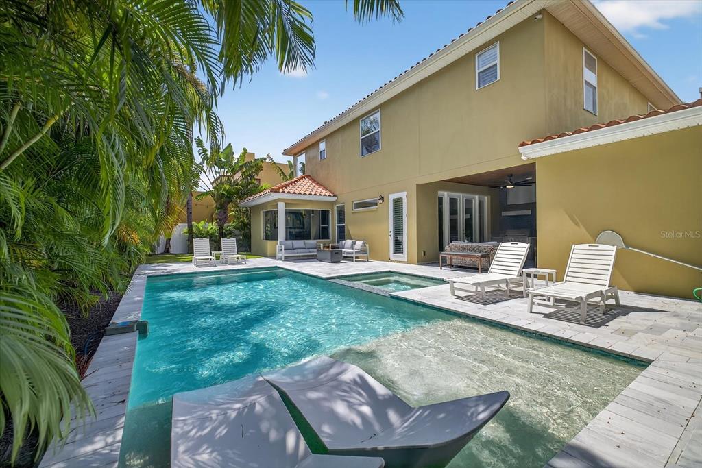 A backyard features a swimming pool with a tanning ledge, lounge chairs, and a patio — 3904 W SANTIAGO STREET, TAMPA, FL