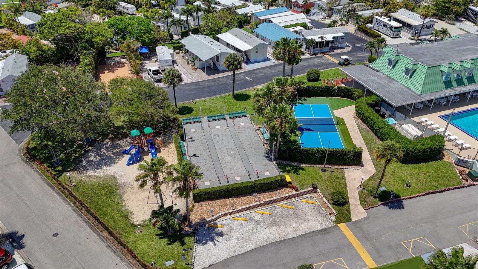 An aerial view shows a playground, shuffleboard courts, a pickleball court, and a swimming pool — 900 Juno Ocean Walk, Juno Beach FL 33408, JUNO BEACH, FL