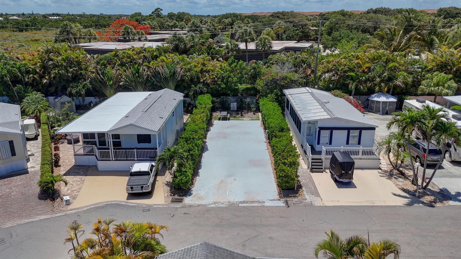 An aerial view shows two mobile homes separated by a paved lot and lush hedges — 900 Juno Ocean Walk, Juno Beach FL 33408, JUNO BEACH, FL