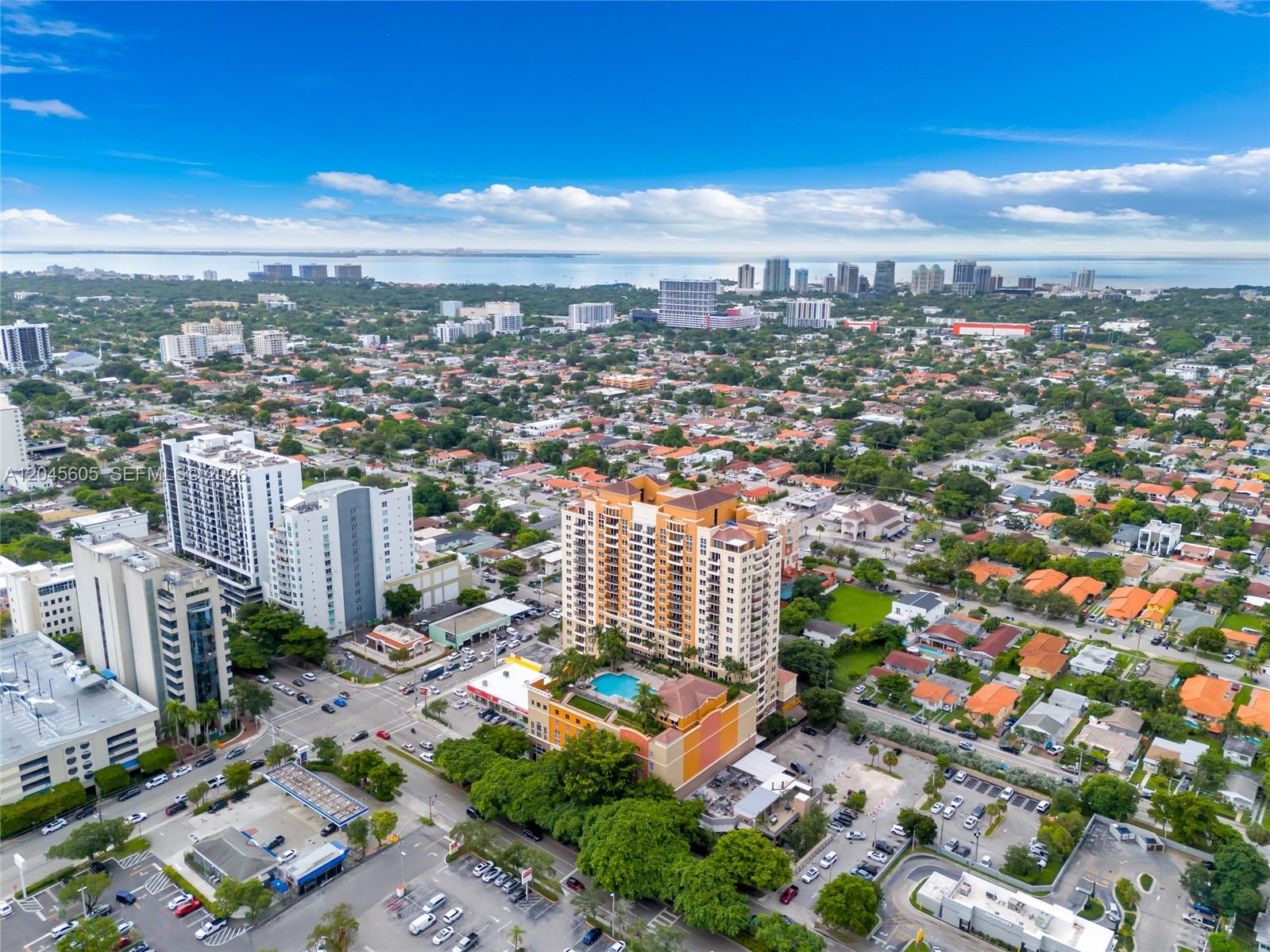An aerial view shows a tall orange apartment building with a pool surrounded by suburban neighborhoods — 3232 SW 22nd Ter # 804, Miami FL 33145, MIAMI, FL
