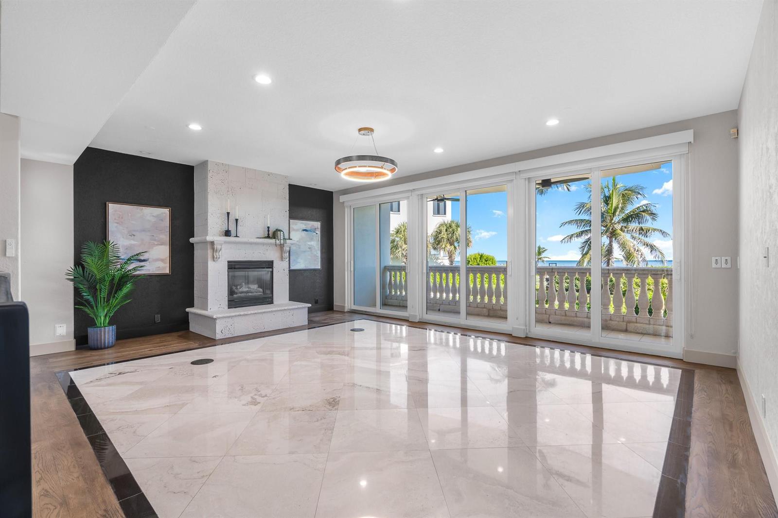 A living room features a fireplace, marble flooring, and sliding glass doors opening to a balcony — 1796 Bay Drive # 1796, Pompano Beach FL 33062, POMPANO BEACH, FL