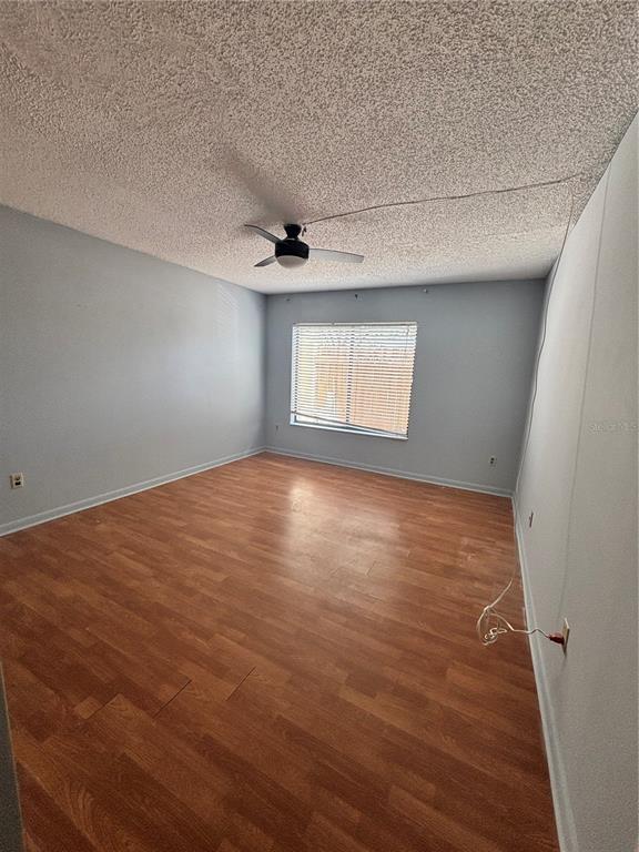 An empty bedroom features light blue walls, wood-look flooring, and a ceiling fan — 2487 HARBOUR WAY, WINTER PARK, FL