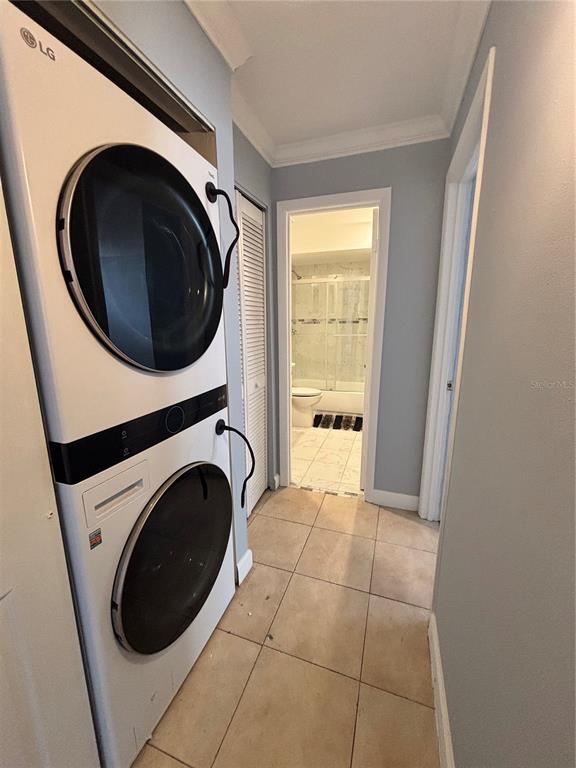 A laundry area with a stacked LG washer and dryer leads into a tiled bathroom — 2487 HARBOUR WAY, WINTER PARK, FL