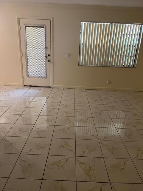 A room with light-colored tile flooring, a white door with a screen, and vertical blinds — 207 Capri E # 207, Delray Beach FL 33484, DELRAY BEACH, FL
