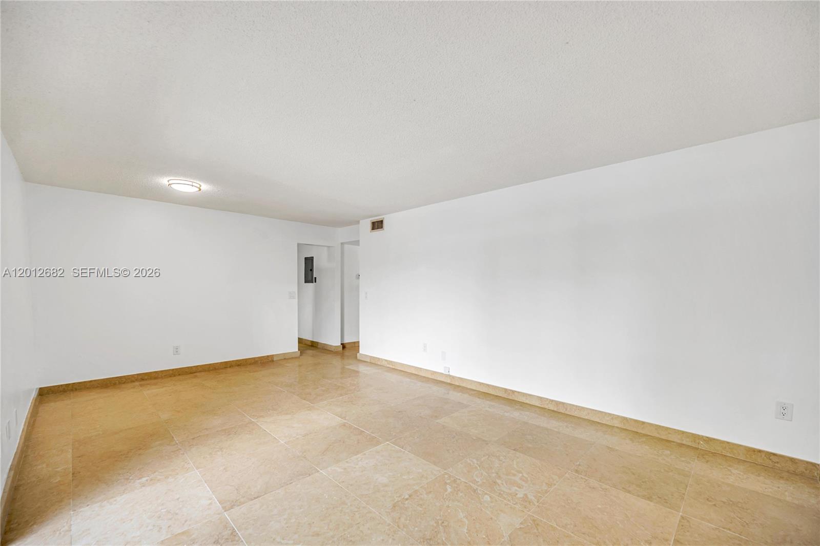 An empty room features white walls, a textured ceiling, and light-colored square floor tiles — 7757 SW 86th St # 213, Miami FL 33143, MIAMI, FL