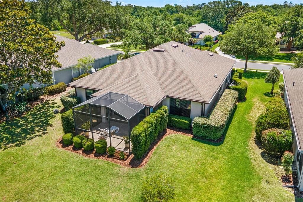 An aerial view of a house with a screened-in patio and landscaped hedges — 6115 LANDINGS BOULEVARD, LADY LAKE, FL