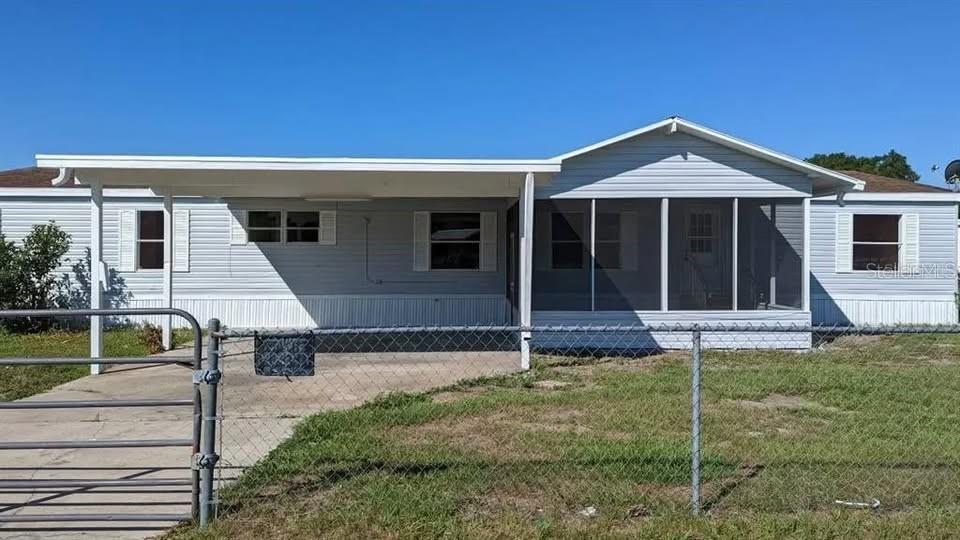 A light blue manufactured home features a front carport and an attached screened-in porch — 4300 MEADOW RIDGE AVENUE, MULBERRY, FL