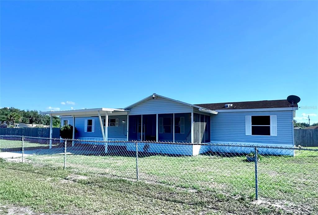 A light blue manufactured home features a screened-in porch and a metal carport — 4300 MEADOW RIDGE AVENUE, MULBERRY, FL