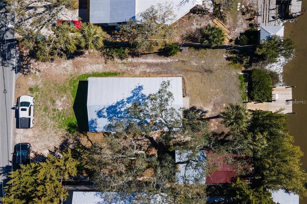 An aerial view shows a rectangular building, a smaller structure, and a dock on water — 1170 WHIDDON AVENUE, CEDAR KEY, FL