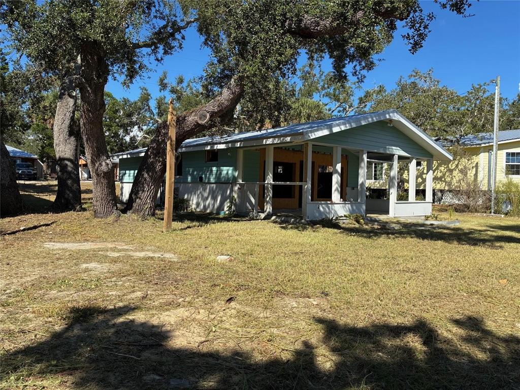 A light blue single-story house with a front porch sits on a grassy lot — 1170 WHIDDON AVENUE, CEDAR KEY, FL