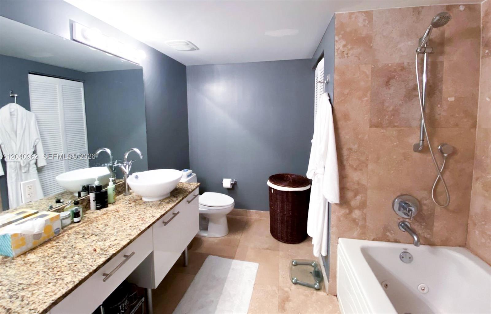 A bathroom features a granite vanity, vessel sink, toilet, and a tiled shower-tub combination — 41 SE 5th St # 1006, Miami FL 33131, MIAMI, FL