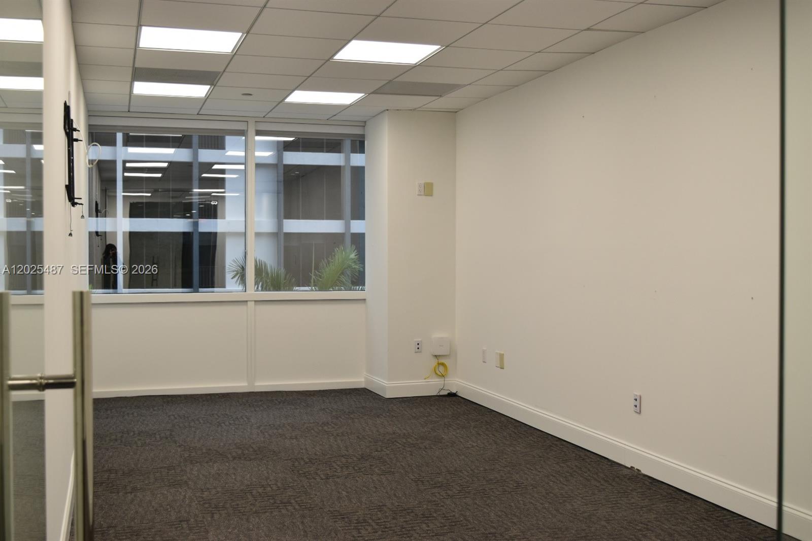 An empty office space features gray carpet, white walls, and large windows with exterior views — 1200 Brickell Ave # 425, Miami FL 33131, MIAMI, FL