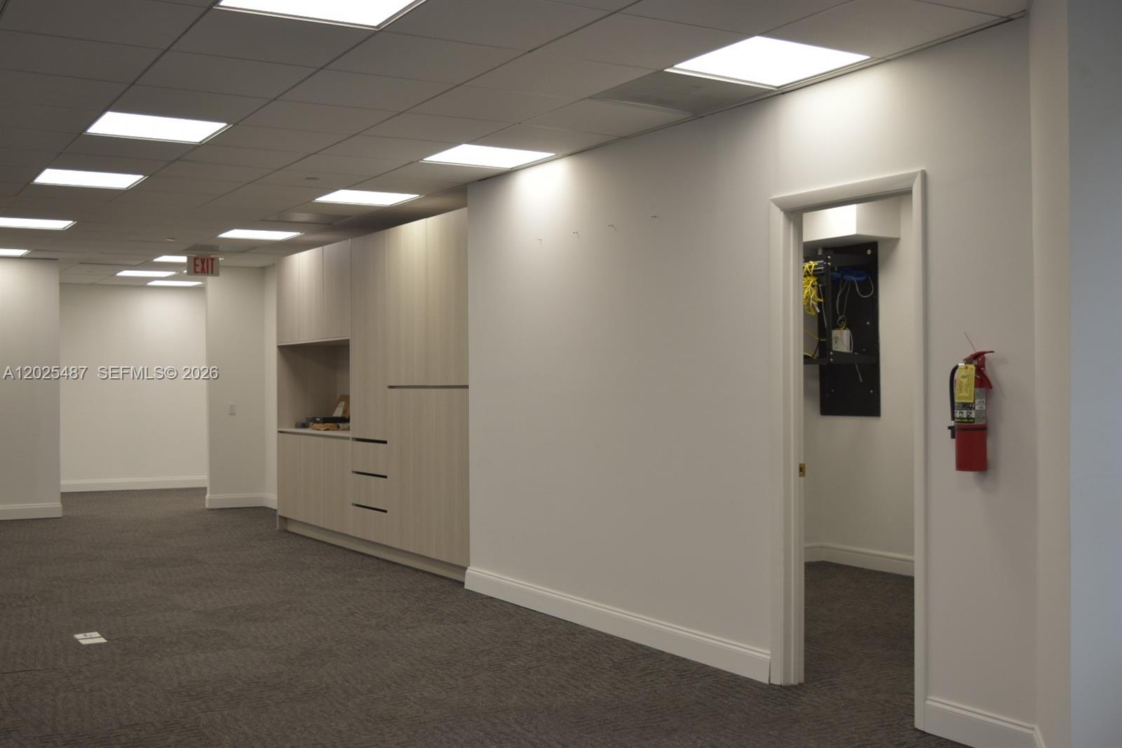 An office hallway features light wood cabinetry, a small utility closet, and a fire extinguisher — 1200 Brickell Ave # 425, Miami FL 33131, MIAMI, FL