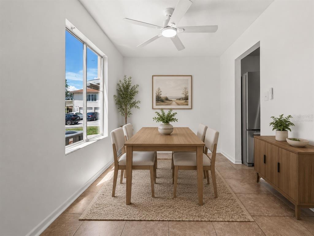 A dining room features a wooden table, four chairs, a ceiling fan, and a sideboard — 1016 SPRING MEADOW DRIVE UNIT 12, KISSIMMEE, FL