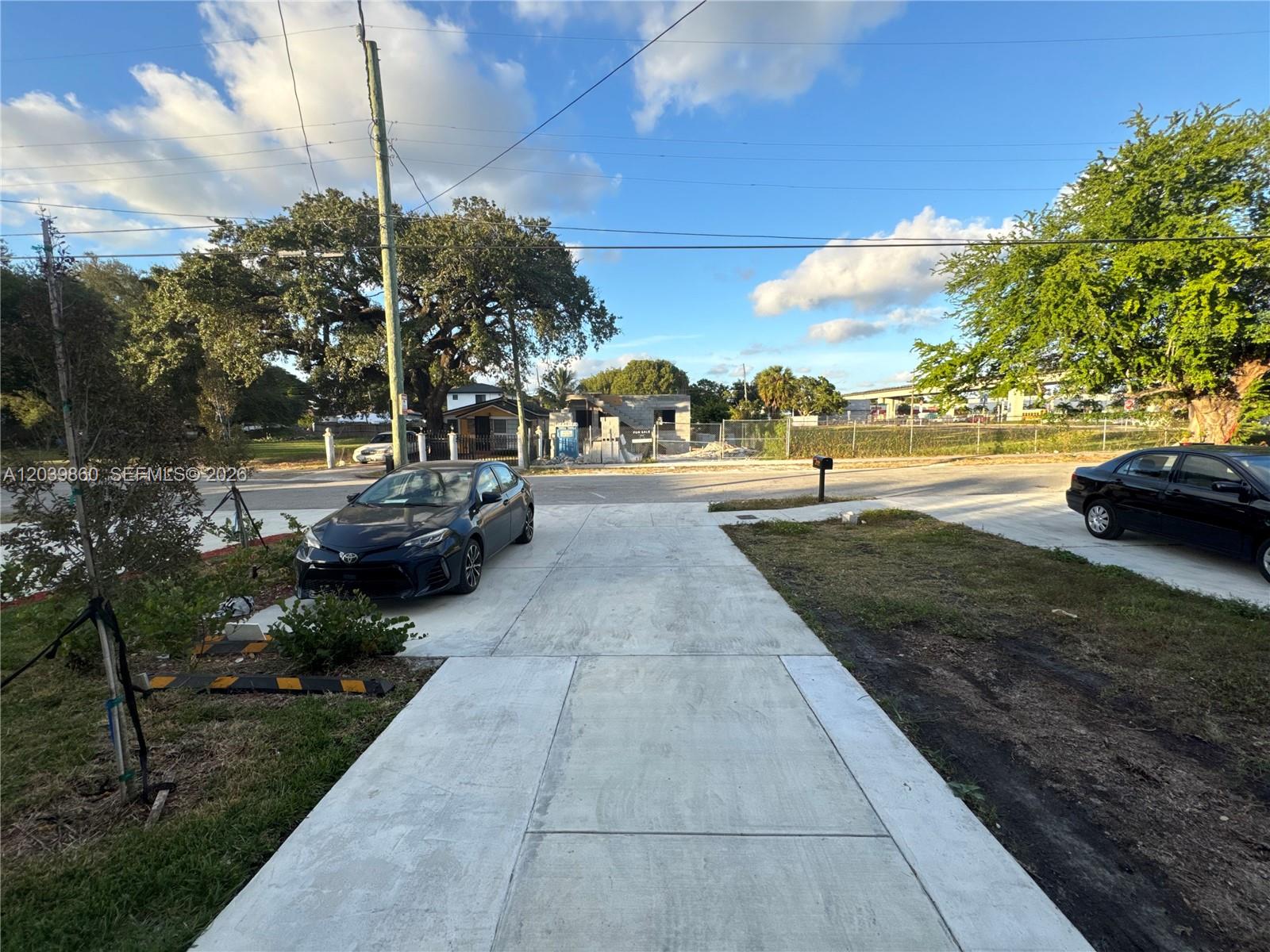 A concrete driveway leads toward a street with a parked car and a construction site — 2730 NW 44th Steet # 3, Miami FL 33142, MIAMI, FL